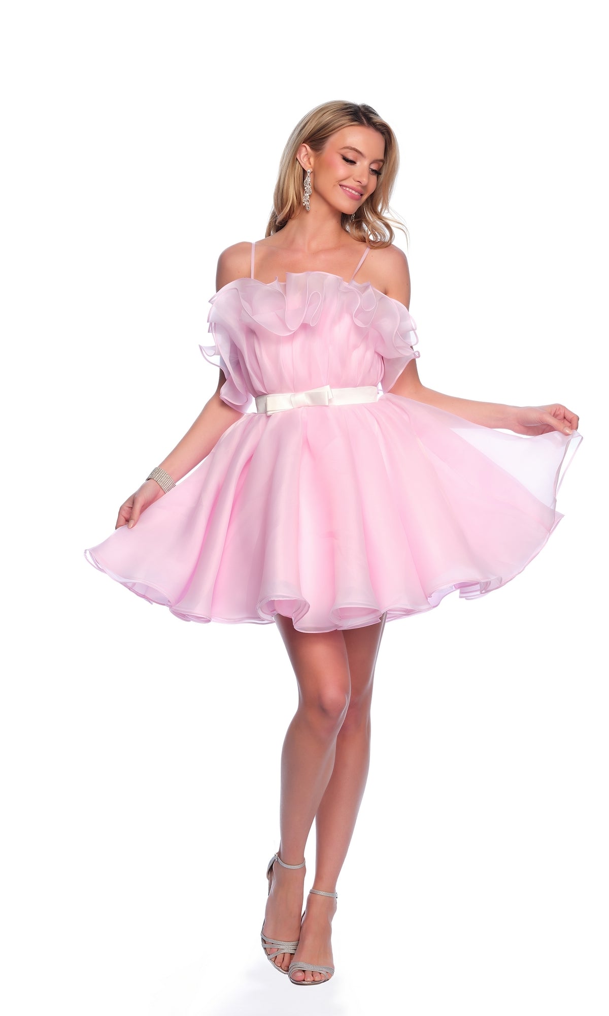 Woman in the Dave and Johnny Short Pink Ruffle Hoco Dress 11730 with a white belt and silver high heels, posing against a white background.